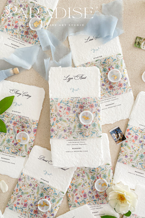 Add a touch of botanical beauty and fine art elegance to your event with our handmade paper wedding menus, crafted from 100% cotton rag paper with delicately torn deckled edges. Each menu features a vibrant floral vellum wrap paired with a soft silk ribbon and wax seal, creating an exquisite balance between organic texture and romantic detail. The minimalist typography allows the floral design to shine, making these menus perfect for garden weddings, spring celebrations and outdoor receptions.