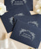 Navy wedding envelopes with white ink address printing, styled flat lay with ivory florals, wax seals, and greenery, perfect for classic and elegant invitation suites.