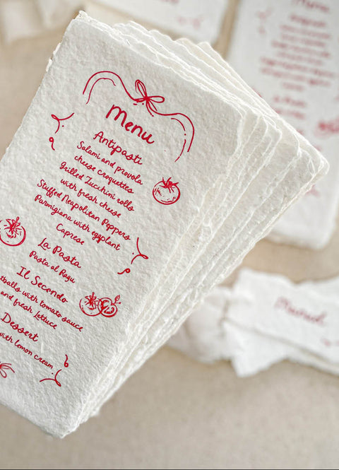 Infuse your tablescape with joyful artistry through our handmade paper menus with whimsical icons - a charming fusion of playfulness and elegance. Each piece is crafted on luxury cotton paper with soft deckled edges and illustrated with hand-drawn food and floral motifs in vivid ink. Perfect for Italian, rustic, or destination weddings, these menus bring warmth, creativity, and personality to your reception setting.