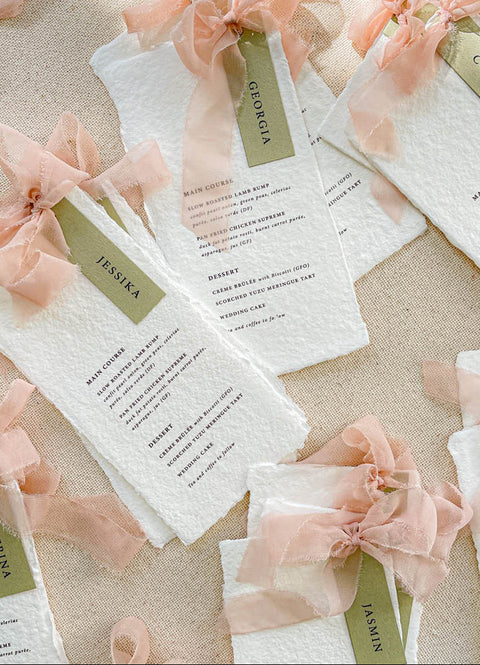 Add elegance and personalization to your tables with our handmade paper menus with name tags, crafted from luxury cotton paper with naturally deckled edges. Each menu features a custom guest name tag tied with a soft blush chiffon ribbon, blending artistry and function. Perfect for romantic, garden, or fine-art weddings, these menus double as place cards - creating a cohesive, bespoke dining experience.