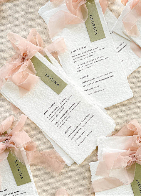 Add elegance and personalization to your tables with our handmade paper menus with name tags, crafted from luxury cotton paper with naturally deckled edges. Each menu features a custom guest name tag tied with a soft blush chiffon ribbon, blending artistry and function. Perfect for romantic, garden, or fine-art weddings, these menus double as place cards - creating a cohesive, bespoke dining experience.