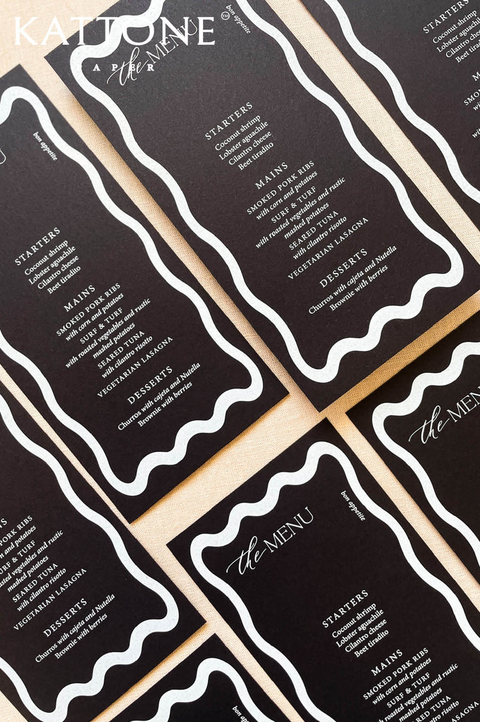 Close-up of black wedding menu showing clean typography and wax seal accent.