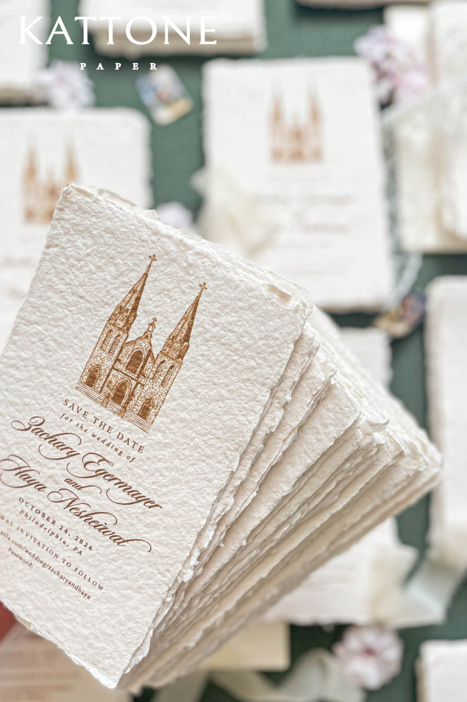Stacked handmade save the date cards showcasing textured cotton paper and venue illustration.