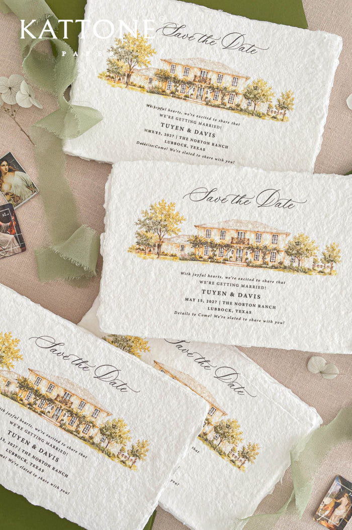 Angled overhead close-up of handmade paper save the date card with deckled edges, elegant black calligraphy, custom watercolor estate illustration, warm yellow and green landscape details, olive green stationery, and soft sage ribbon styling