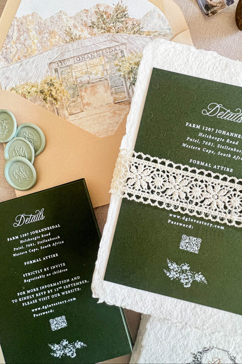 A styled flat-lay of a wedding invitation suite featuring a dark green envelope with a white lace band, matching green cards with white text, a cream floral insert card, and pale green wax seals on a neutral background.