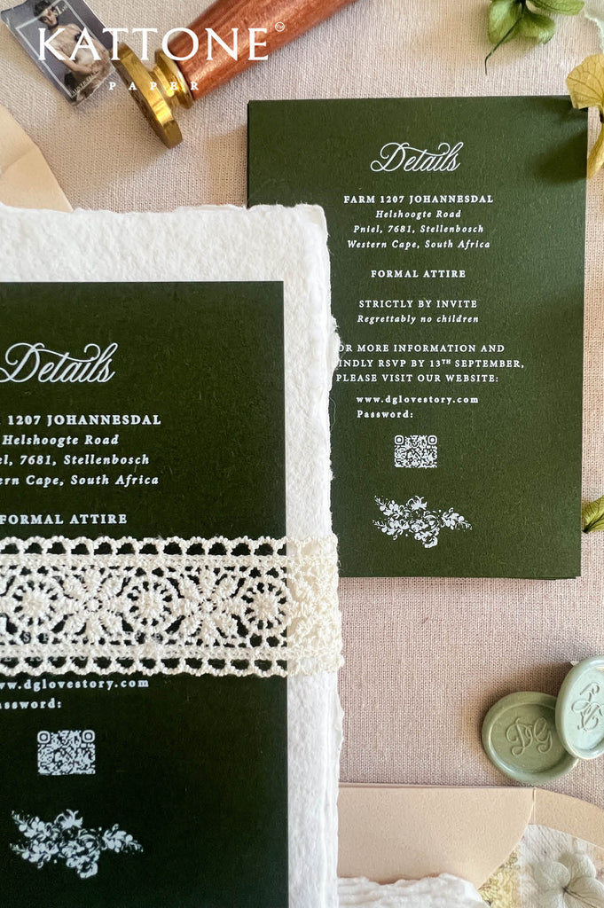 Dark green wedding invitation suite with white lace trim, displayed on a beige fabric background with wax seals, a gold pen, and floral accents. The suite includes a main invitation card, a details card, and a matching envelope.
