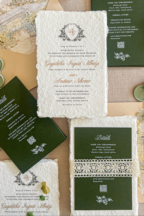 Top-down flat lay of luxury forest green wedding invitation suite featuring ivory handmade deckled-edge paper, botanical monogram crest, dark green details cards, cream lace band, sage green wax seals, beige envelopes, and custom watercolor venue envelope liners styled on a neutral linen background