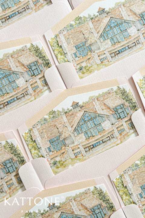 Watercolor wedding venue illustration printed inside blush pink invitation envelopes