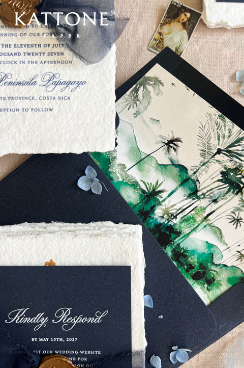 Top-down detail view of luxury navy and ivory wedding stationery featuring calligraphy-addressed dark navy envelope, handmade deckled-edge invitation, monogram wax seal, sheer navy ribbon, RSVP card, and elegant destination wedding styling