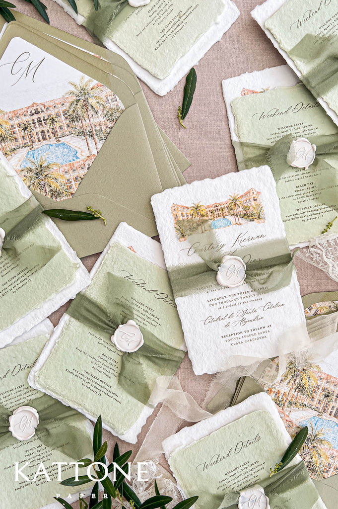 Top-down detail view of olive green wedding envelope with custom watercolor liner featuring palm trees, Mediterranean-style architecture, bright blue pool scenery, and elegant monogram initials beside handmade paper wedding stationery