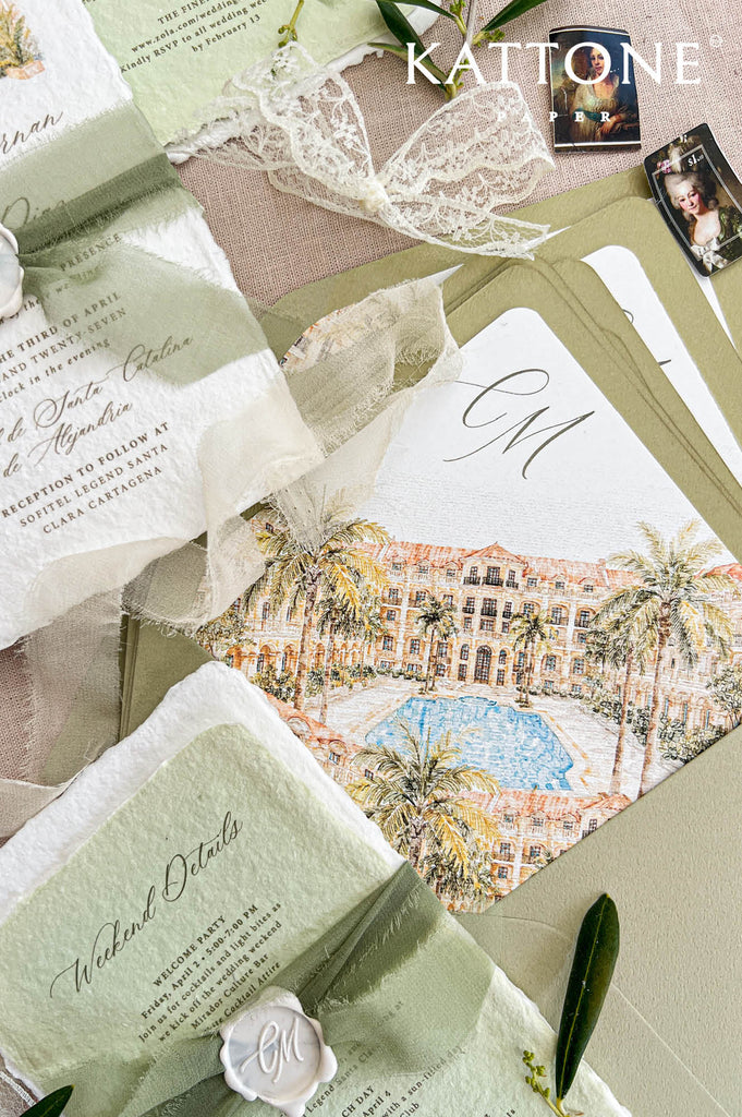 Overhead styled flat lay of handmade paper wedding invitations with watercolor resort artwork, sage green details cards, olive envelopes, soft green ribbon, personalized wax seals, botanical greenery, and tropical destination wedding stationery