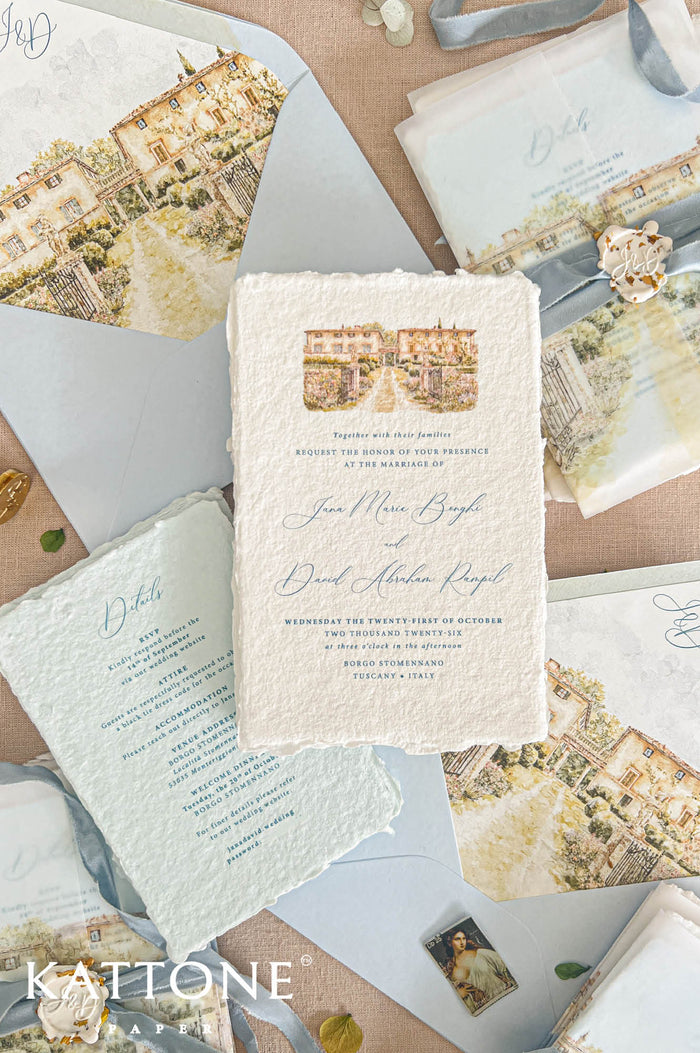 Top-down flat lay of luxury Tuscany wedding invitation suite featuring handmade deckled-edge paper, pale blue envelopes with watercolor Borgo Stomennano venue liners, translucent vellum jackets, dusty blue silk ribbon, personalized wax seals, and elegant Italian destination wedding stationery