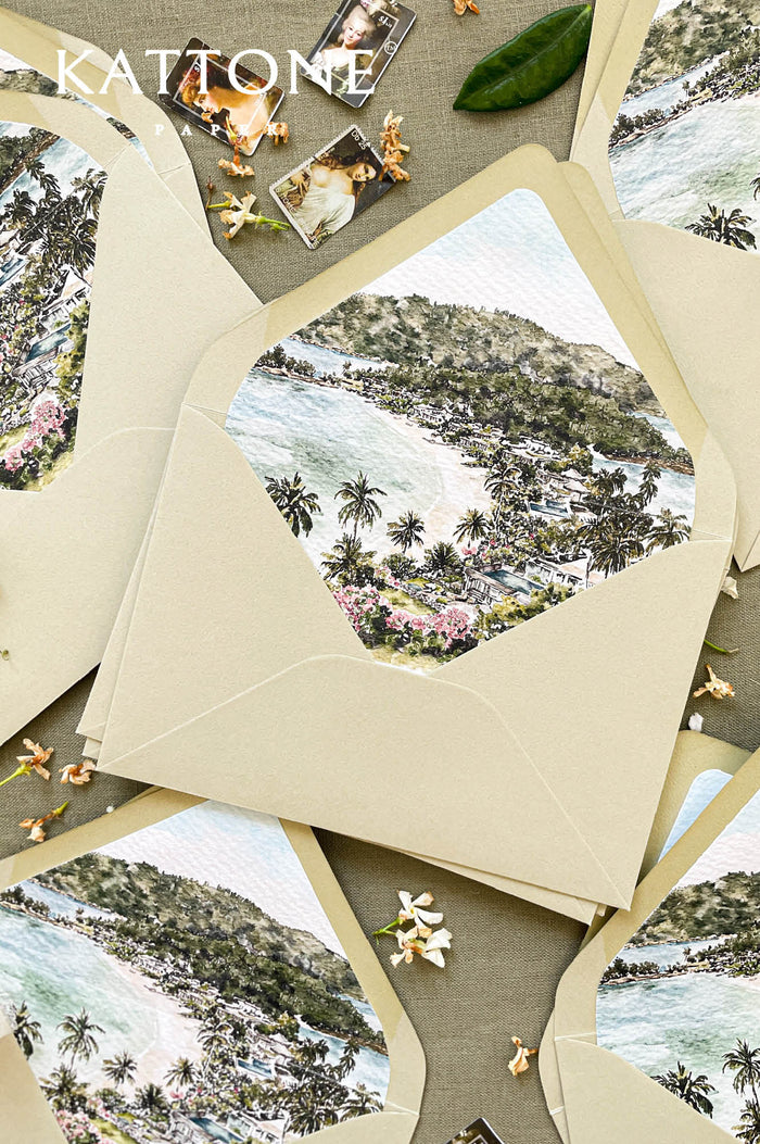 Neutral wedding envelopes with custom watercolor envelope liners featuring a hand-painted coastal destination scene, designed for elegant destination weddings.