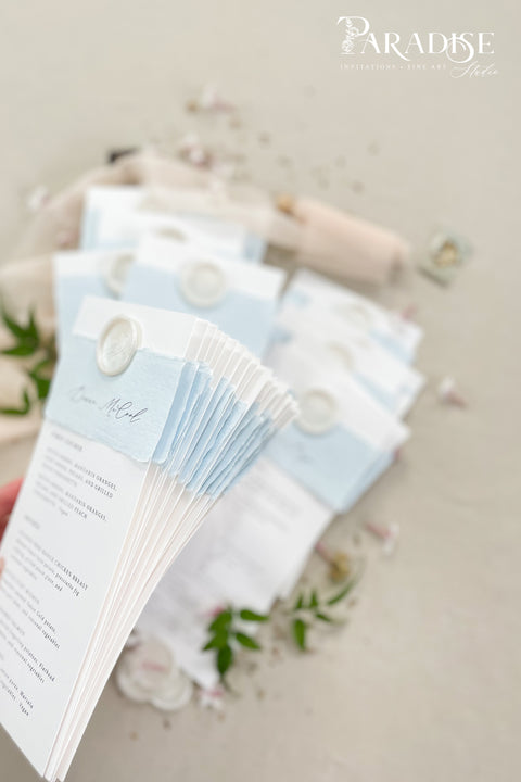 Elevate your table setting with our handmade paper wedding menus with personalized name tags, designed to merge fine-art elegance and functionality. Crafted on luxury cotton paper with a soft deckled edge, each menu features a hand-torn band and custom wax seal that doubles as a keepsake place card. The subtle dusty blue tones add a refined, romantic touch to coastal, garden, or destination weddings.
