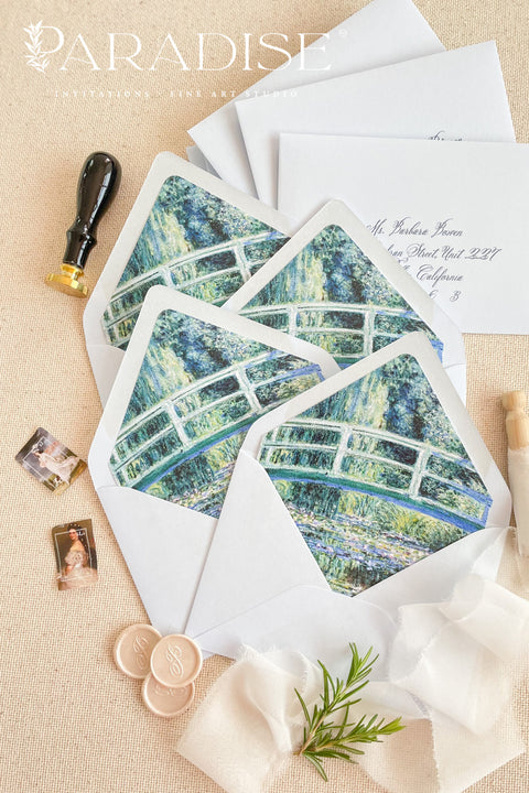 Stacked haze envelopes with decorative art liners, styled with ribbon and wax seals for refined, gallery-inspired wedding stationery.