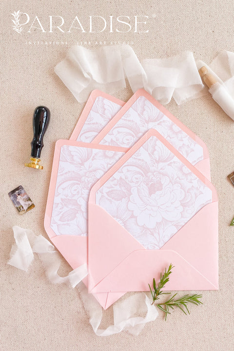 Blush envelopes featuring decorative liners, photographed open to reveal delicate floral patterns for elegant wedding stationery.