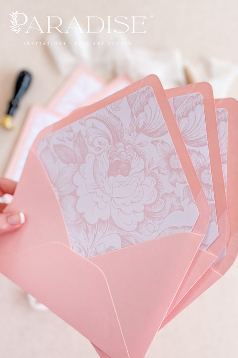Blush envelopes featuring decorative liners, photographed open to reveal delicate floral patterns for elegant wedding stationery.