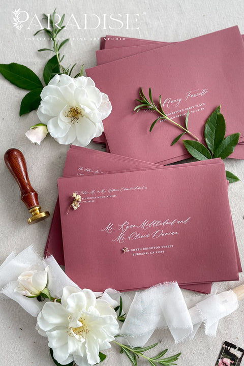 Wedding envelopes with white ink address printing, crafted from premium paper in a muted romantic tone and styled to highlight crisp lettering and refined stationery quality.