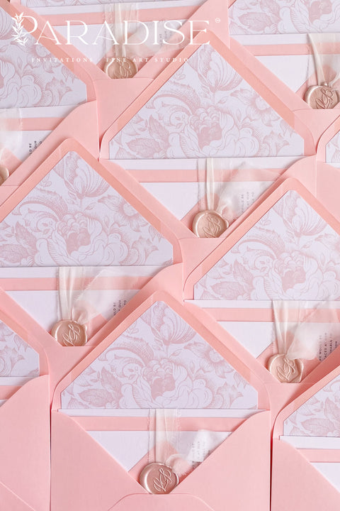 Blush envelopes featuring decorative liners, photographed open to reveal delicate floral patterns for elegant wedding stationery.