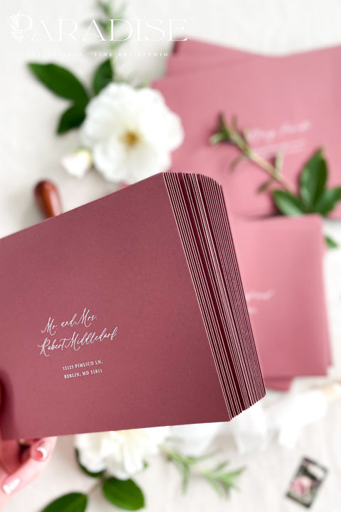 Wedding envelopes with white ink address printing, crafted from premium paper in a muted romantic tone and styled to highlight crisp lettering and refined stationery quality.