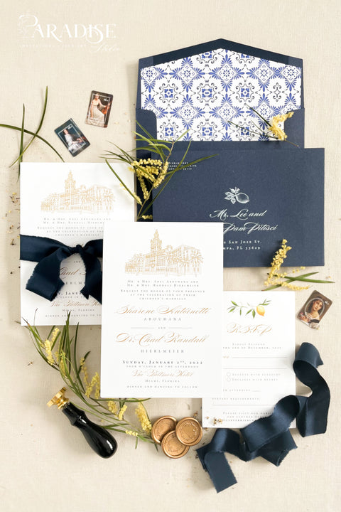 Inspired by the golden light and charm of European summers, this wedding invitation suite combines custom hand-drawn architecture with delicate watercolor lemons for a design that’s both luxurious and full of life. The venue illustration is created by hand, transforming your wedding location into a piece of art that sets the tone for your day. Paired with rich navy envelopes, an ornate blue patterned liner, and velvet ribbon accents, the result is a suite that exudes elegance and personality.