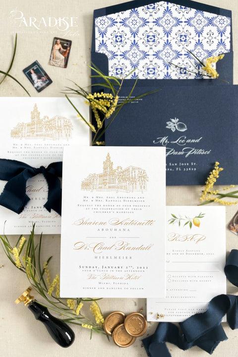 Inspired by the golden light and charm of European summers, this wedding invitation suite combines custom hand-drawn architecture with delicate watercolor lemons for a design that’s both luxurious and full of life. The venue illustration is created by hand, transforming your wedding location into a piece of art that sets the tone for your day. Paired with rich navy envelopes, an ornate blue patterned liner, and velvet ribbon accents, the result is a suite that exudes elegance and personality.