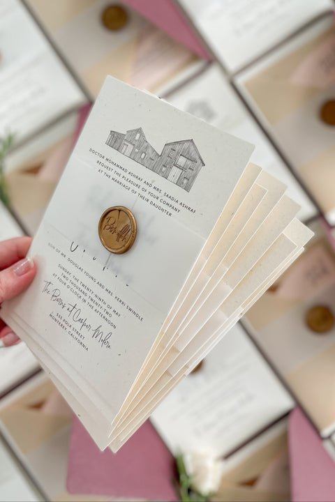 This wedding invitation suite beautifully blends fine art design and personal storytelling, featuring a custom hand-drawn illustration of your wedding venue. Each suite is printed on luxury textured paper, layered with translucent vellum, and sealed with a gold wax emblem, creating an elegant, timeless presentation. Designed for couples who appreciate artistry and sentiment, it’s a true keepsake that celebrates your love and the place where your story begins.