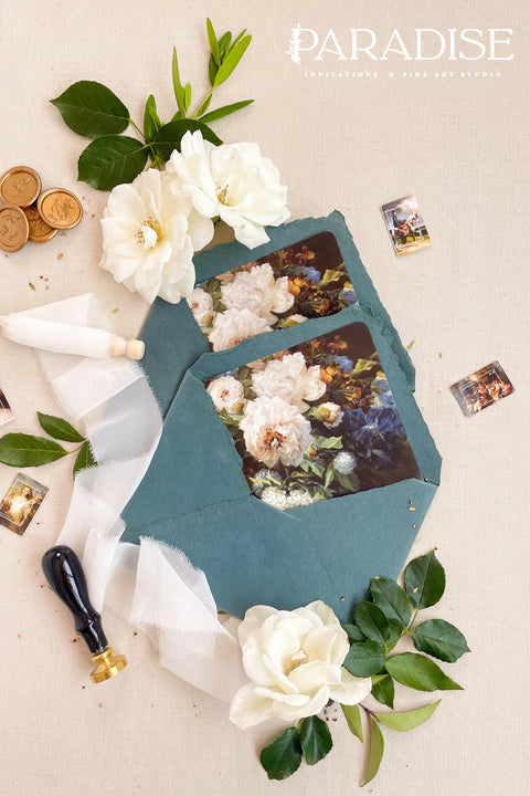 Emerald wedding envelopes with floral envelope liners, styled flat lay with white florals, greenery, and wax seals, perfect for romantic and botanical invitation suites.