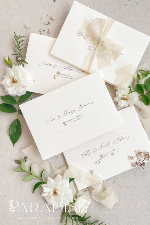 Stack of coco linen envelopes with address printing displaying consistent color, textured paper surface, and structured luxury wedding stationery finish.