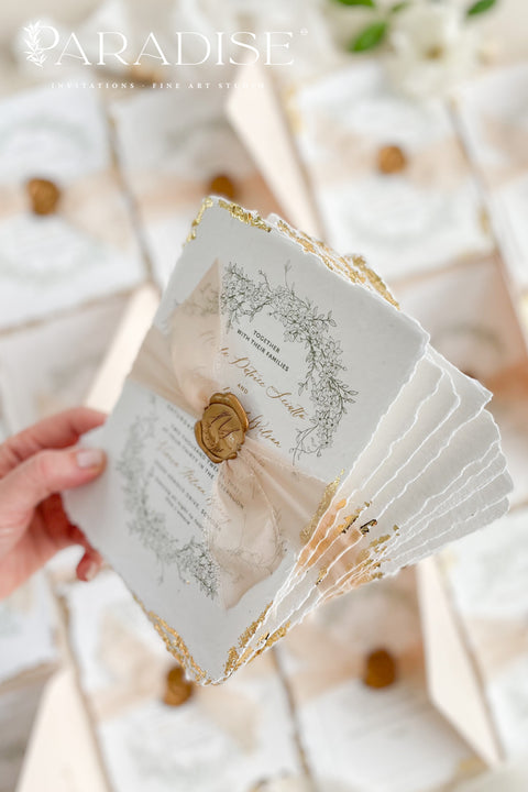 This exquisite wedding invitations suite offers a blend of timeless sophistication and eco-conscious elegance. Printed on premium, sustainable deckled edge fine art stationery, each invitation features a delicate golden leaf detail, adding a touch of luxurious shimmer. The suite is thoughtfully assembled with beautiful silk ribbons and sealed with a personalized wax seal, creating a stunning and tactile keepsake for your guests.