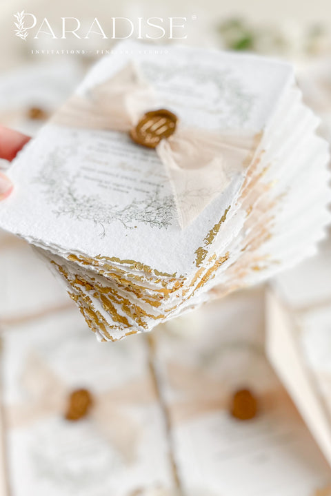 This exquisite wedding invitations suite offers a blend of timeless sophistication and eco-conscious elegance. Printed on premium, sustainable deckled edge fine art stationery, each invitation features a delicate golden leaf detail, adding a touch of luxurious shimmer. The suite is thoughtfully assembled with beautiful silk ribbons and sealed with a personalized wax seal, creating a stunning and tactile keepsake for your guests.
