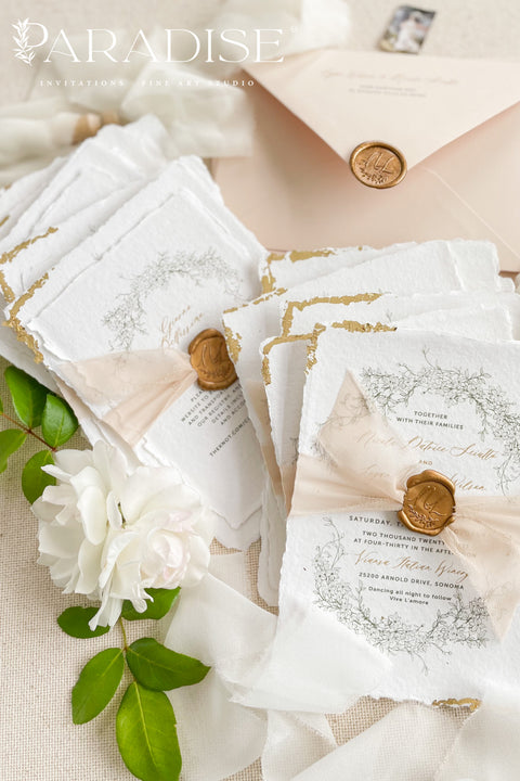 This exquisite wedding invitations suite offers a blend of timeless sophistication and eco-conscious elegance. Printed on premium, sustainable deckled edge fine art stationery, each invitation features a delicate golden leaf detail, adding a touch of luxurious shimmer. The suite is thoughtfully assembled with beautiful silk ribbons and sealed with a personalized wax seal, creating a stunning and tactile keepsake for your guests.