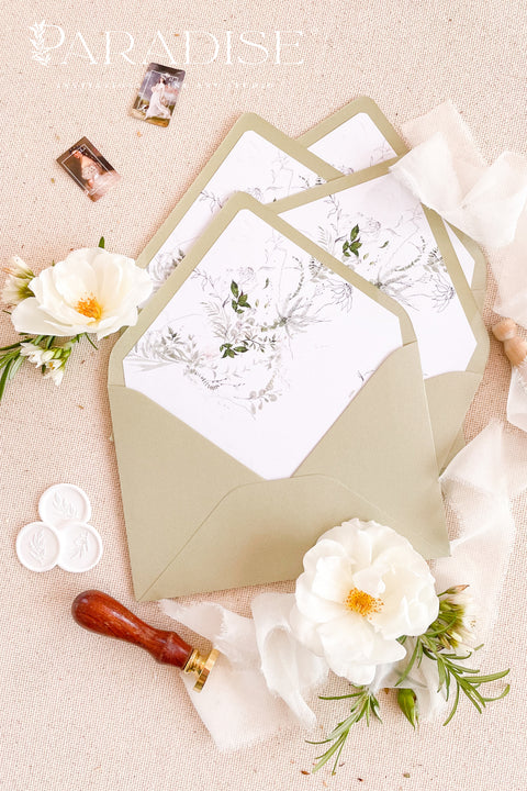 Close-up of matcha envelopes revealing watercolor botanical liners with soft green leaves and florals, highlighting fine-art stationery craftsmanship.