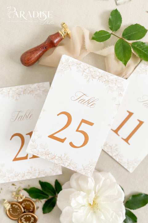 Clean white cardstock paired with rich copper typography creates a beautifully modern yet romantic table number design. Delicate botanical borders add a soft, ornamental touch, giving each card a refined and cohesive wedding-day presence. Perfect for elegant, garden, rustic-chic, or contemporary celebrations, this style blends minimalist clarity with decorative charm.