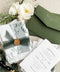 This handmade paper wedding invitation suite is designed for couples who cherish natural beauty and fine art craftsmanship. Each invitation is printed on luxury deckled-edge cotton paper, offering a rich, tactile texture that reflects the care and artistry poured into every detail. Encased in a botanical vellum jacket and hand-tied with a deep green silk ribbon and wax seal, this suite embodies organic elegance. It feels like a keepsake from nature itself - graceful, heartfelt, and timeless. 