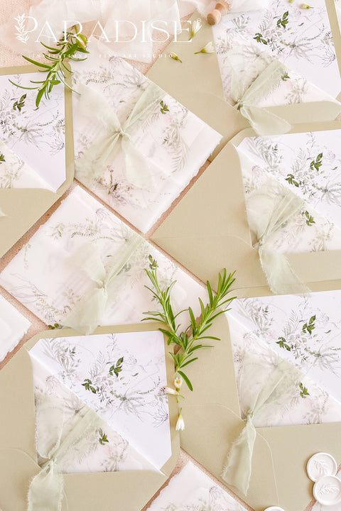 Stack of matcha wedding envelopes with watercolor botanical liners, styled with ribbon and florals for romantic, nature-inspired stationery.