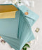 Sage wedding envelopes with golden envelope liners crafted from premium paper, featuring soft green exteriors and metallic gold interiors for elegant fine art stationery.