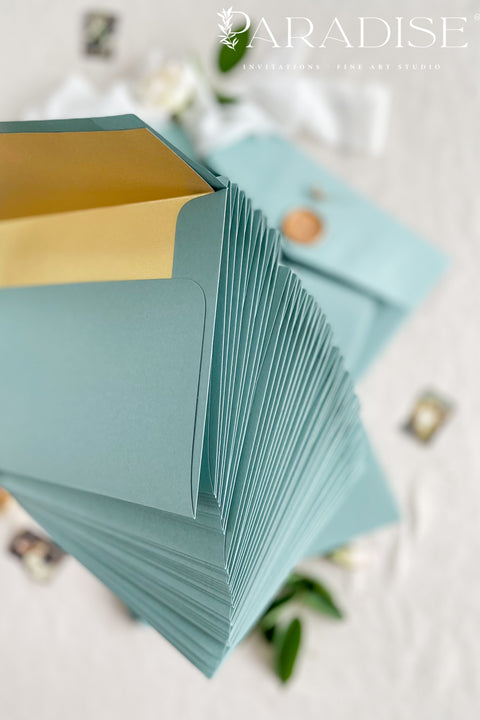 Sage wedding envelopes with golden envelope liners crafted from premium paper, featuring soft green exteriors and metallic gold interiors for elegant fine art stationery.