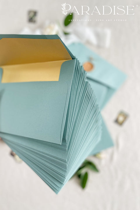 Sage wedding envelopes with golden envelope liners crafted from premium paper, featuring soft green exteriors and metallic gold interiors for elegant fine art stationery.