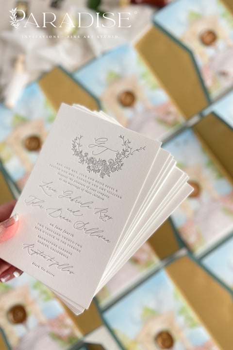 Announce your wedding with timeless artistry through this letterpress wedding invitation suite, featuring a custom watercolor vellum jacket that beautifully captures the romance of your venue. Each invitation is hand-pressed on luxury cotton paper, its deep letterpress impressions paired with soft deckled edges to evoke the elegance of fine art stationery. The suite is wrapped in a vellum overlay adorned with a watercolor venue illustration, sealed with a warm gold wax emblem.