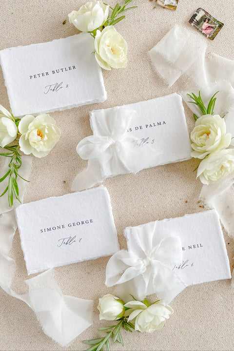 Add refined elegance to your seating display with our handmade paper place cards, crafted from luxurious cotton rag paper and finished with naturally torn deckled edges. Each card features minimalist typography paired with a soft fine-art aesthetic, making them perfect for weddings, intimate dinners, bridal showers, and elevated celebrations. With their organic texture and timeless look, these artisan-crafted cards bring sophistication and effortless beauty to any tablescape.
