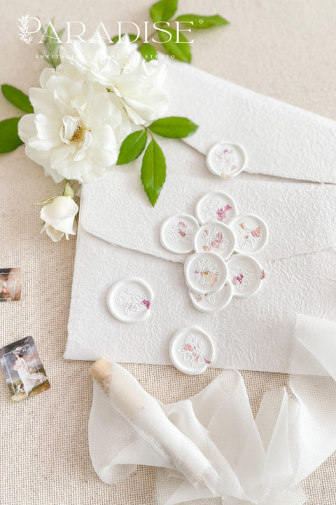 Soft white wax seals adorned with delicate dried rose petals bring an ethereal, romantic finish to wedding invitations, envelopes, and fine-paper details. Each seal is individually hand-poured, capturing subtle variations that make every piece feel organic, timeless, and artfully imperfect. Designed to elevate both classic and modern stationery, these botanical wax seals add texture, warmth, and a refined sense of luxury to your paper suite.