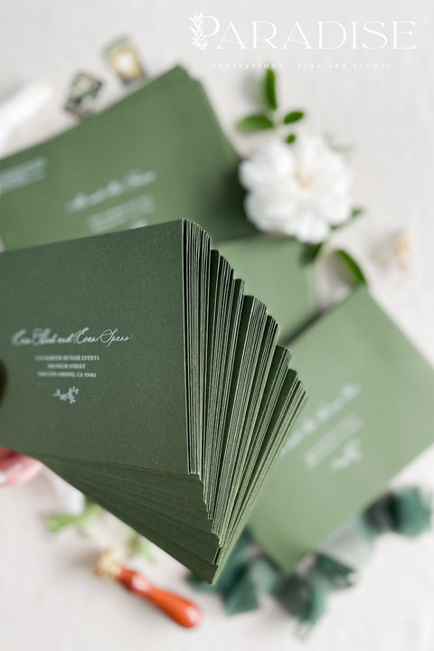 Elegant deep green wedding envelopes with white ink address printing, styled flat lay with wax seals and florals, perfect for modern and classic invitation suites.