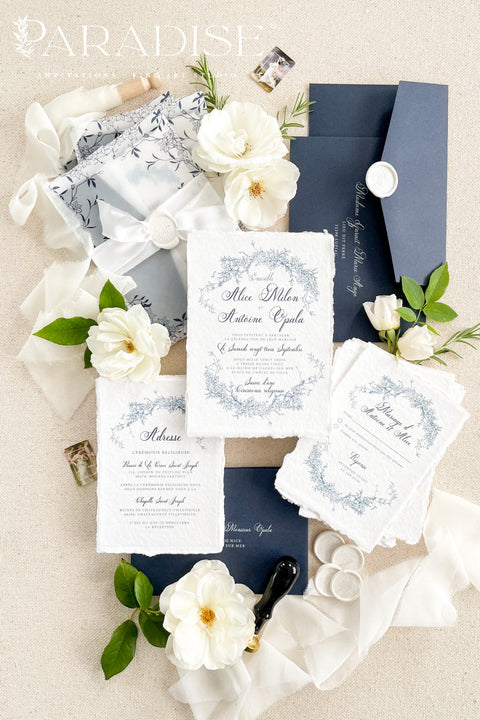 Celebrate your love with elegance and craftsmanship through our handmade blue fine art wedding invitations, featuring deckled-edge cotton paper, soft botanical designs, and luxurious vellum wraps tied with delicate silk ribbon and a custom wax seal. This suite combines timeless artistry with modern sophistication, perfect for coastal, fine art, or destination weddings seeking a romantic and refined aesthetic.