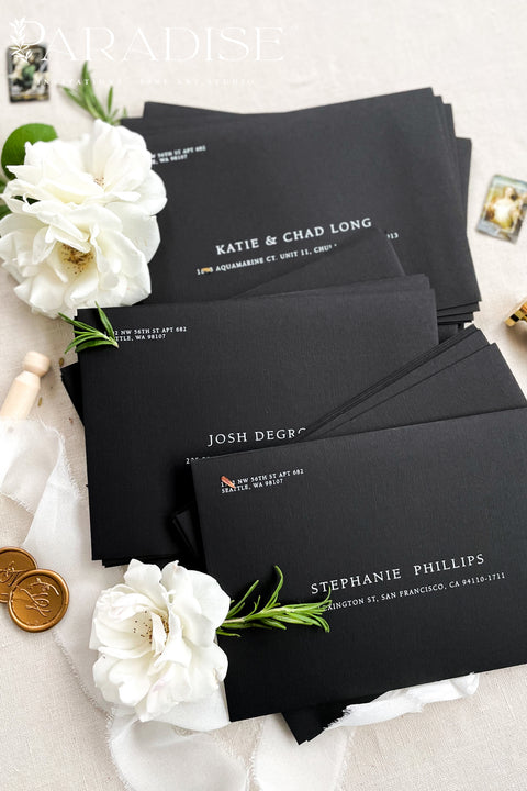 Premium black envelopes with crisp white ink printing, styled for luxury weddings with floral accents and clean, modern presentation.