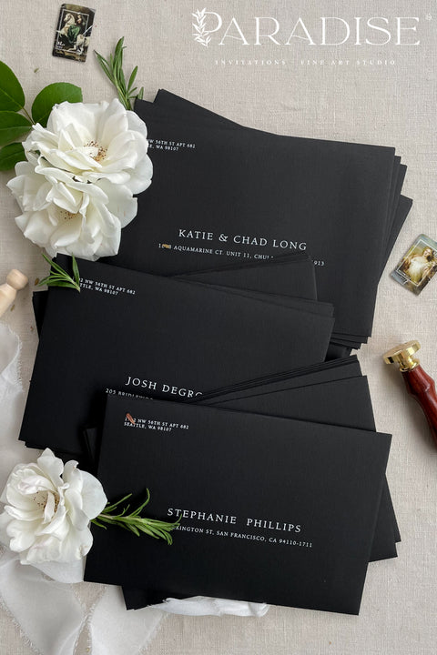 Premium black envelopes with crisp white ink printing, styled for luxury weddings with floral accents and clean, modern presentation.