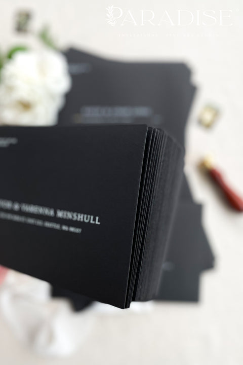 Premium black envelopes with crisp white ink printing, styled for luxury weddings with floral accents and clean, modern presentation.