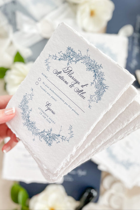 Celebrate your love with elegance and craftsmanship through our handmade blue fine art wedding invitations, featuring deckled-edge cotton paper, soft botanical designs, and luxurious vellum wraps tied with delicate silk ribbon and a custom wax seal. This suite combines timeless artistry with modern sophistication, perfect for coastal, fine art, or destination weddings seeking a romantic and refined aesthetic.
