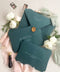 Stack of emerald envelopes with address printing showing consistent color, structured paper stock, and polished presentation for luxury wedding stationery.