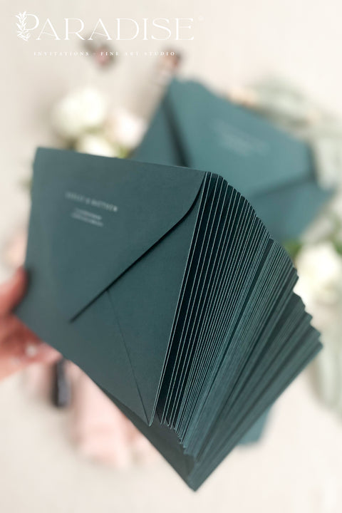 Stack of emerald envelopes with address printing showing consistent color, structured paper stock, and polished presentation for luxury wedding stationery.